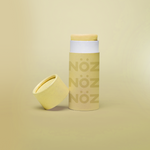 Load image into Gallery viewer, Noz&#39; yellow nose sunscreen with the cap open and leaning up against the side of the cylinder sunscreen container, with a light yellow background.
